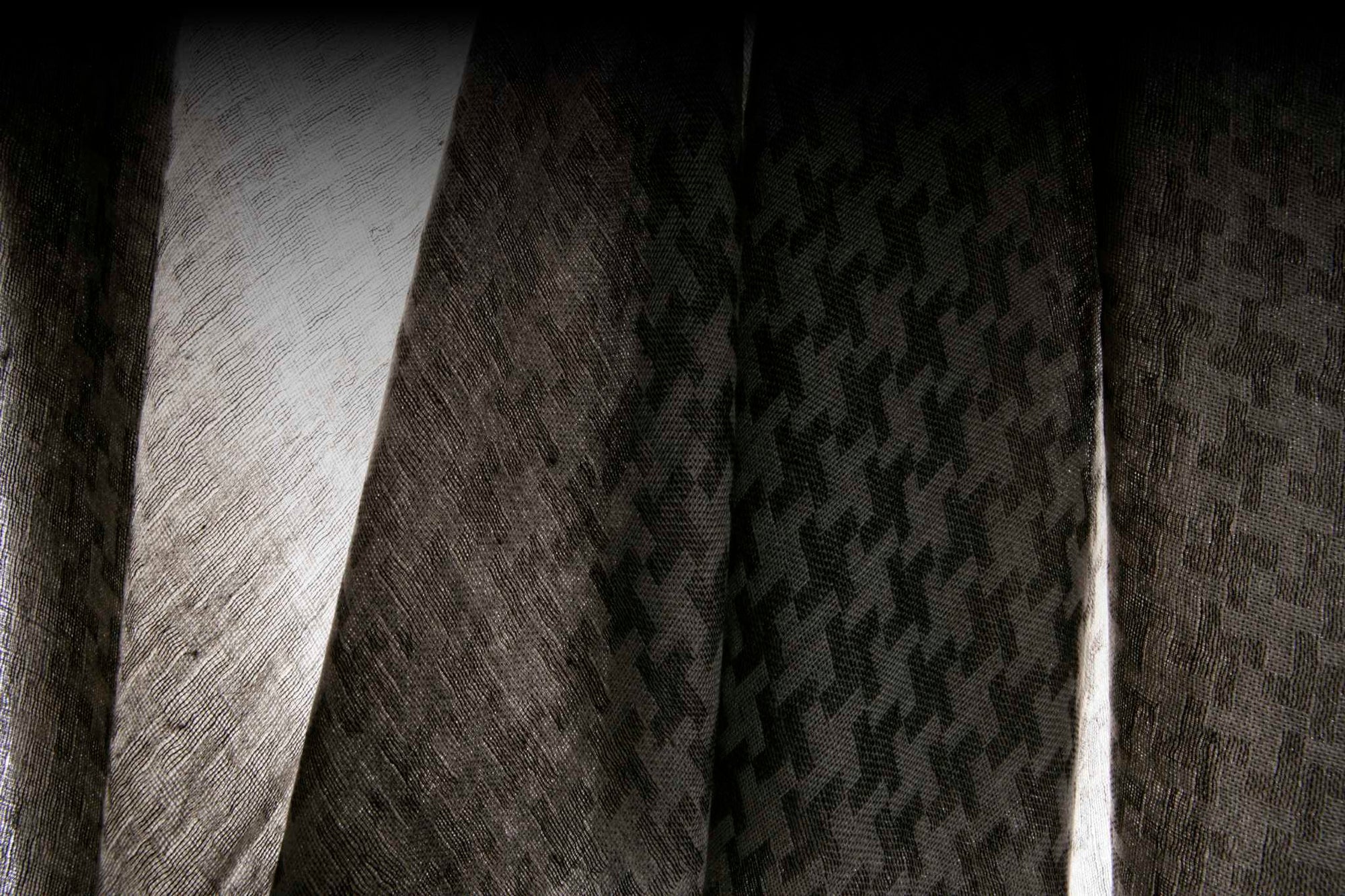 Close-up of a textured cashmere fabric with a houndstooth pattern.