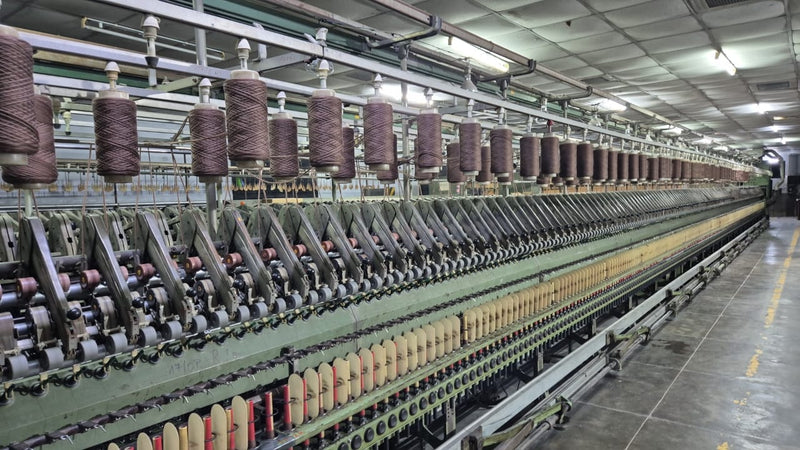 Textile factory with spools of thread on a large spinning machine spinning ulotra fine cashmere yarn by Ezma.